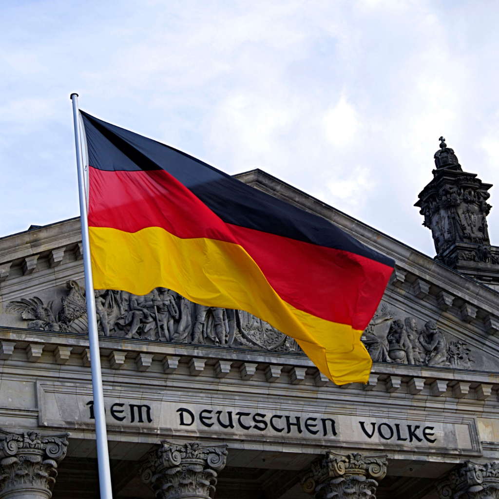 Die deutsche Flagge vor dem Reichstag mit der Inschrift Dem Deutschen Volke
